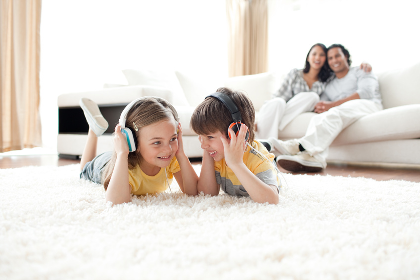 Brother and sister listening music with headphones Brother and sister listening music with headphones lying on the floor